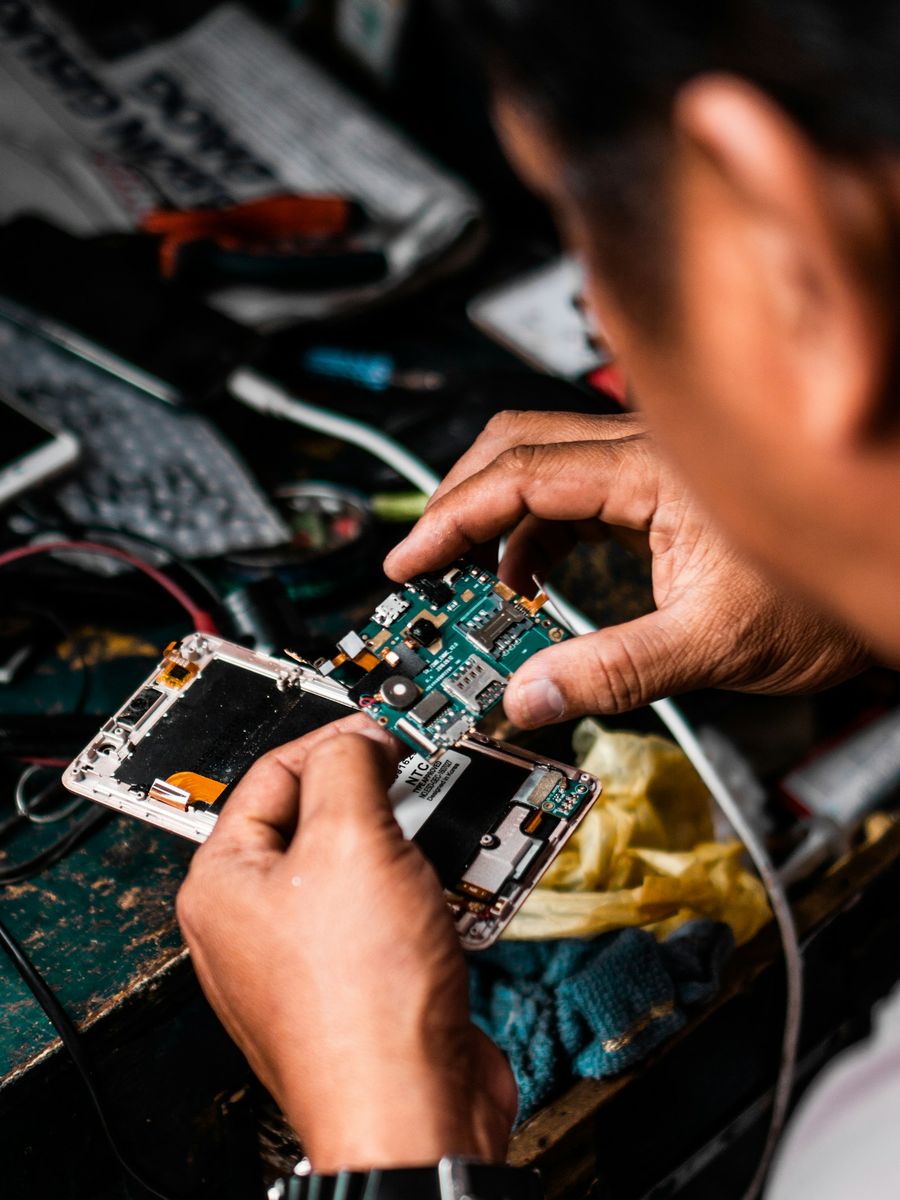 Técnico revisando la placa de un smartphone en el banco de trabajo
